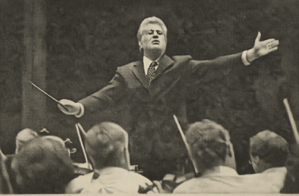 Paul Nadler conducting the Fort Myers Philharmonic orchestra during a performance, styled as a black and white newspaper photograph